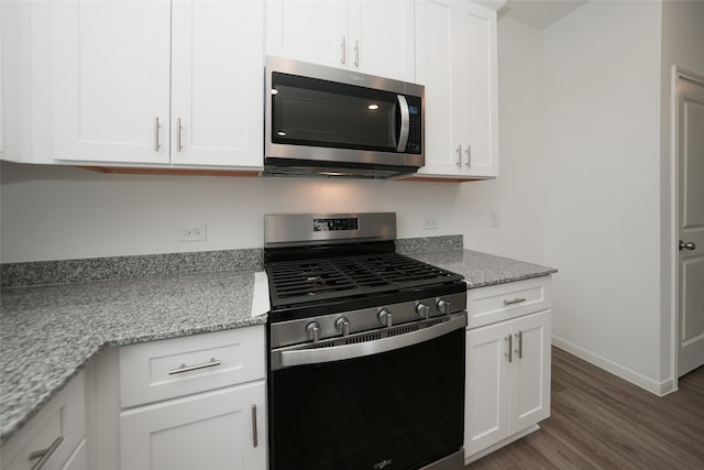 kitchen with white cabinets, light stone countertops, stainless steel appliances, and dark hardwood / wood-style floors