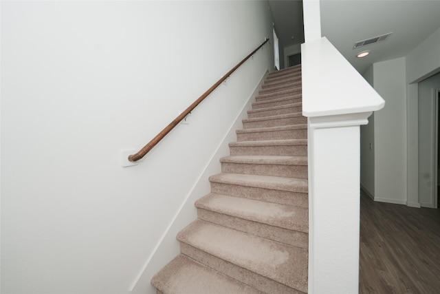 staircase featuring wood-type flooring