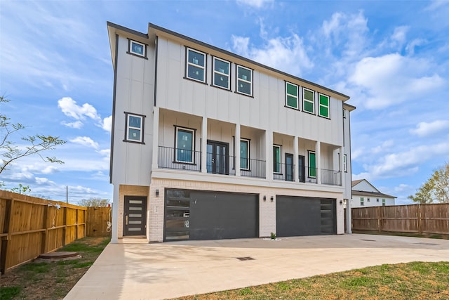 4748 Mallow St, Houston, TX 77033 - view of front of house with concrete driveway, fence, an attached garage, board and batten siding, and brick siding