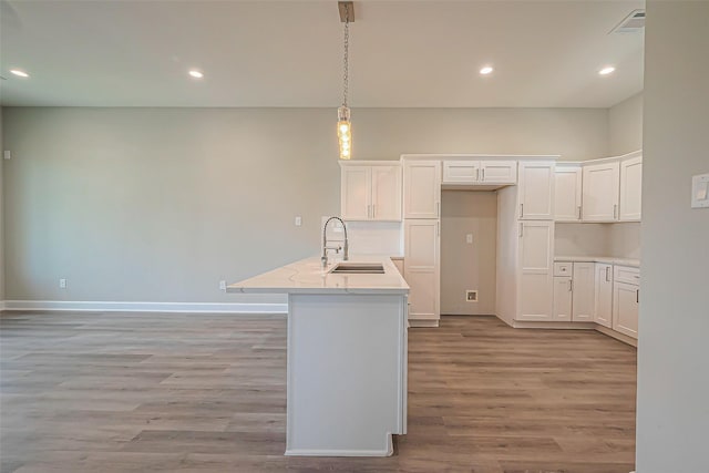 4748 Mallow St, Houston, TX 77033 - kitchen with white cabinets, a sink, recessed lighting, and light wood-type flooring