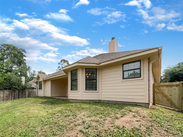 rear view of house featuring a yard