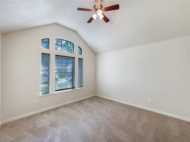 bonus room featuring a textured ceiling, light colored carpet, vaulted ceiling, and ceiling fan