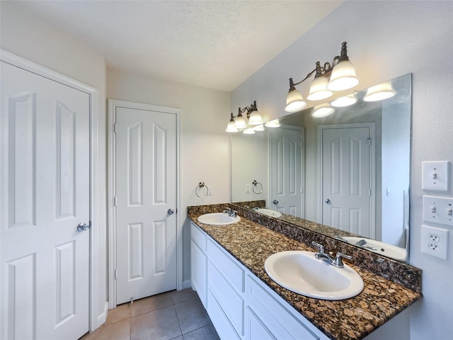 bathroom with tile patterned floors, vanity, and a textured ceiling