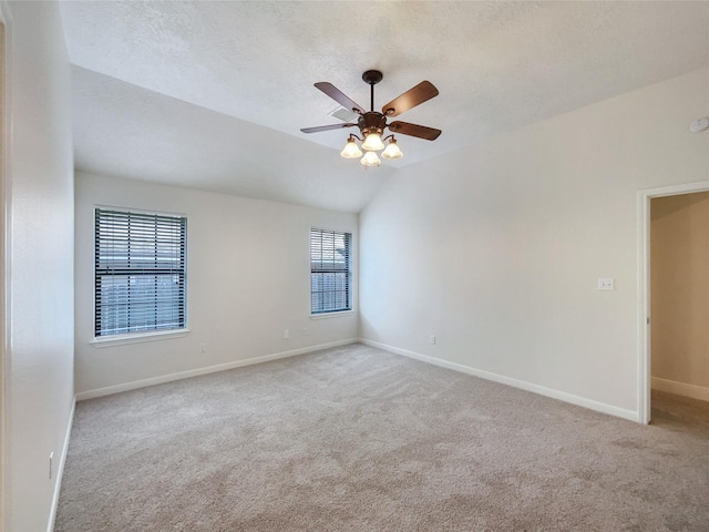 unfurnished room featuring ceiling fan, light colored carpet, a textured ceiling, and vaulted ceiling