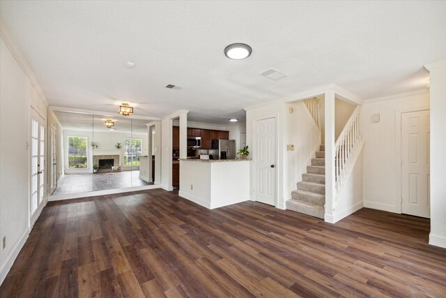 unfurnished living room with crown molding and dark hardwood / wood-style floors