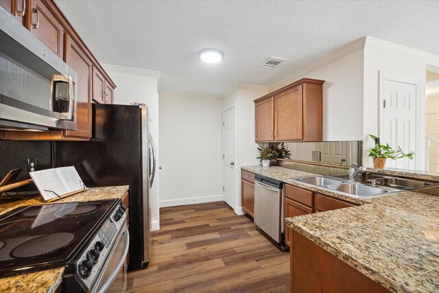 kitchen featuring a textured ceiling, sink, appliances with stainless steel finishes, and dark wood-type flooring