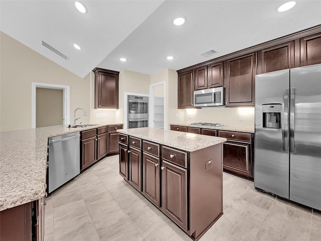 kitchen with dark brown cabinetry, sink, stainless steel appliances, and vaulted ceiling