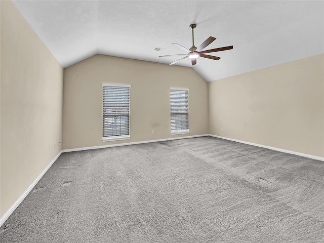 carpeted spare room with ceiling fan and lofted ceiling