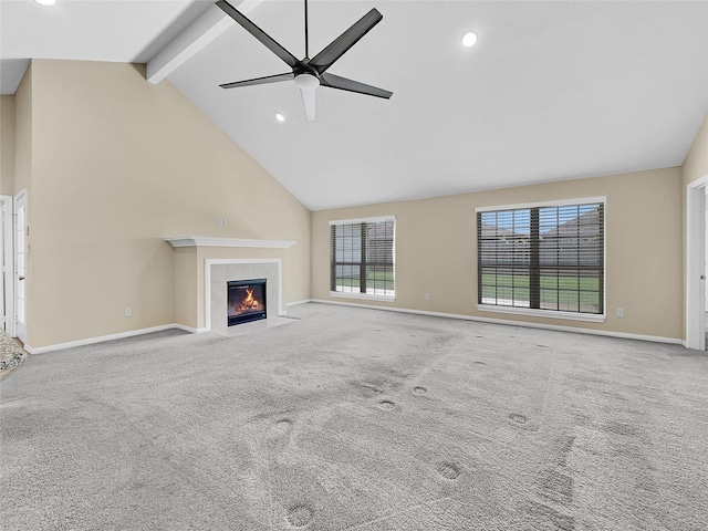 unfurnished living room featuring ceiling fan, beam ceiling, light colored carpet, and a tiled fireplace