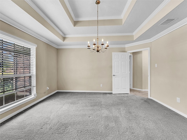 spare room featuring carpet flooring, a chandelier, a raised ceiling, and crown molding