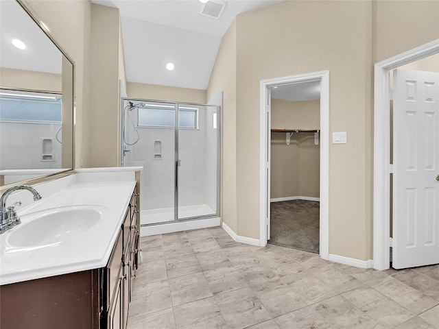 bathroom with a shower with shower door, lofted ceiling, and vanity