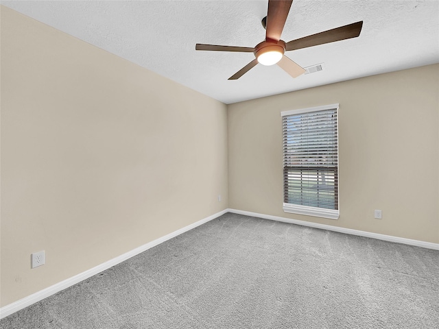 carpeted empty room with ceiling fan and a textured ceiling