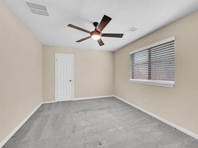 carpeted spare room featuring ceiling fan