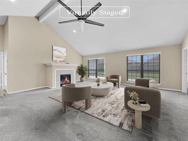 carpeted living room with ceiling fan, beam ceiling, a fireplace, and high vaulted ceiling