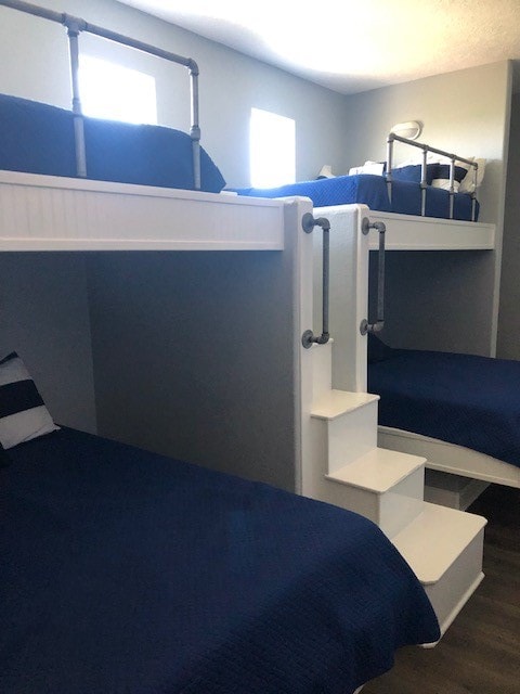 unfurnished bedroom featuring dark wood-type flooring and multiple windows