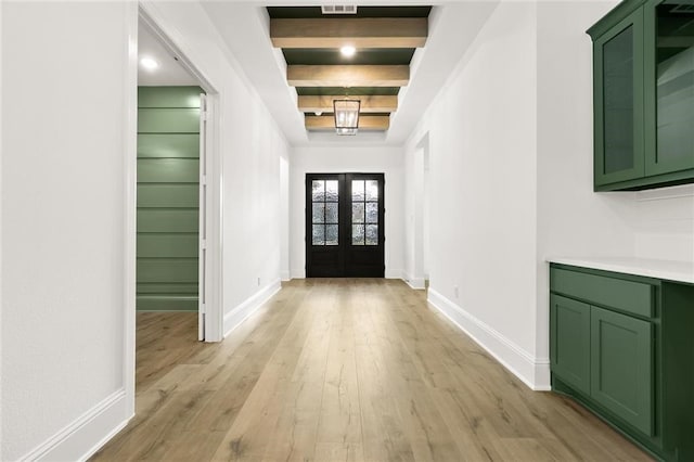 foyer entrance with french doors, beamed ceiling, and light wood-type flooring