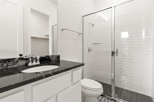 bathroom with vanity, a shower with shower door, and toilet