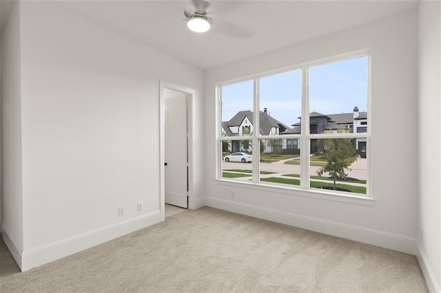 spare room with light carpet and ceiling fan