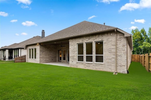 back of property with a patio, ceiling fan, and a lawn