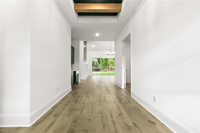 hall featuring light hardwood / wood-style flooring and a notable chandelier