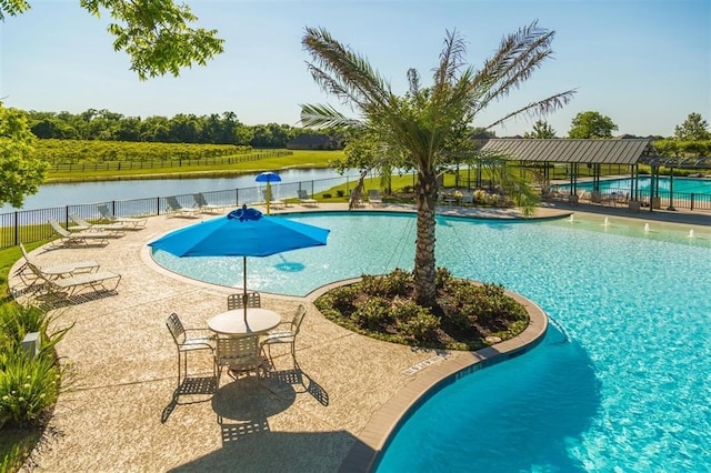 view of swimming pool with a water view and a patio