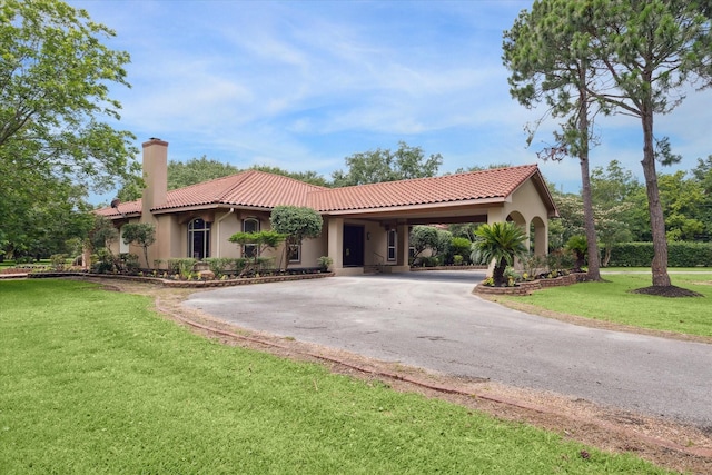 mediterranean / spanish-style home featuring a front lawn and a carport