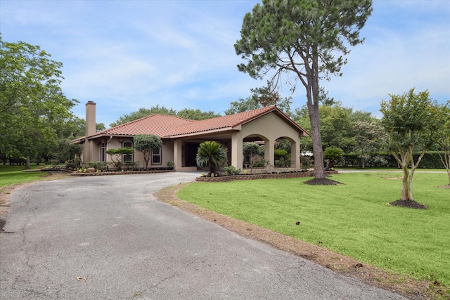 mediterranean / spanish house featuring a front yard