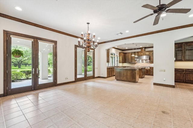 kitchen with hanging light fixtures, a center island, ornamental molding, light tile patterned flooring, and french doors