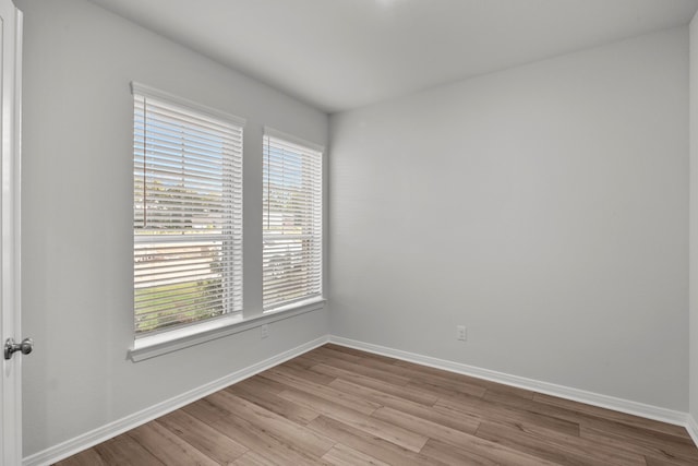 spare room with hardwood / wood-style flooring and plenty of natural light