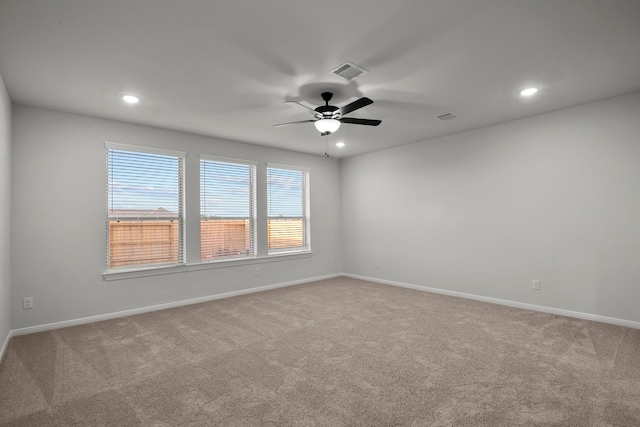 carpeted spare room featuring ceiling fan