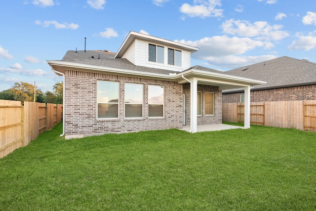 rear view of property featuring a lawn and a patio