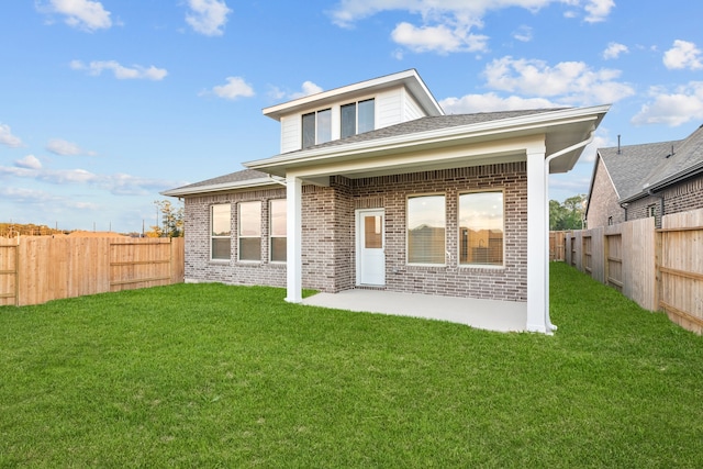 back of property with a lawn and a patio