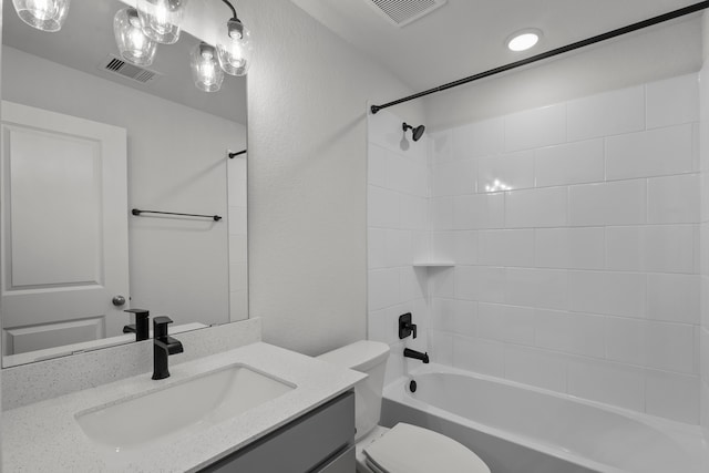 full bathroom with tiled shower / bath, vanity, and toilet