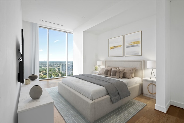 bedroom featuring expansive windows, multiple windows, and light hardwood / wood-style flooring