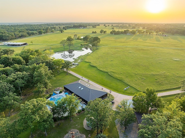 aerial view at dusk with a rural view and a water view