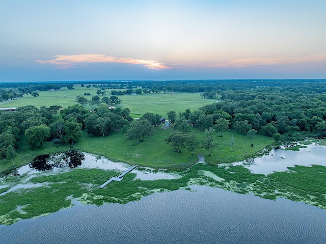 aerial view at dusk with a rural view and a water view