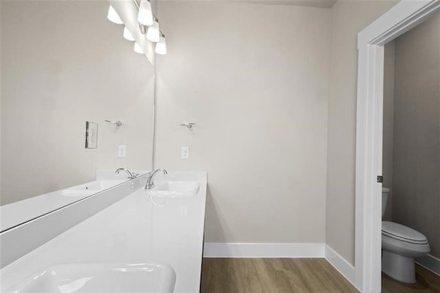 bathroom with wood-type flooring, sink, and toilet