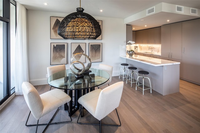 dining area featuring light wood-type flooring and sink