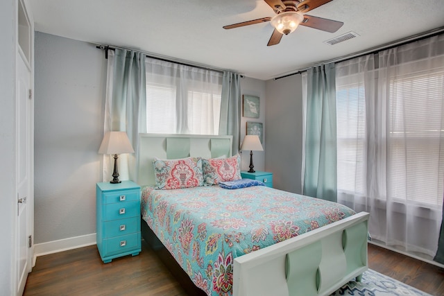 bedroom with ceiling fan, dark hardwood / wood-style floors, and multiple windows