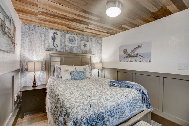 bedroom featuring light wood-type flooring and wooden ceiling