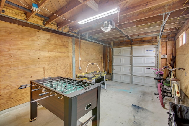 interior space with a garage door opener and wood walls