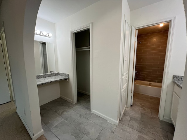 interior space with ensuite bathroom, a closet, and light tile flooring