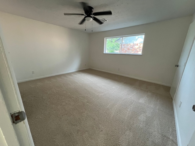 carpeted spare room with ceiling fan