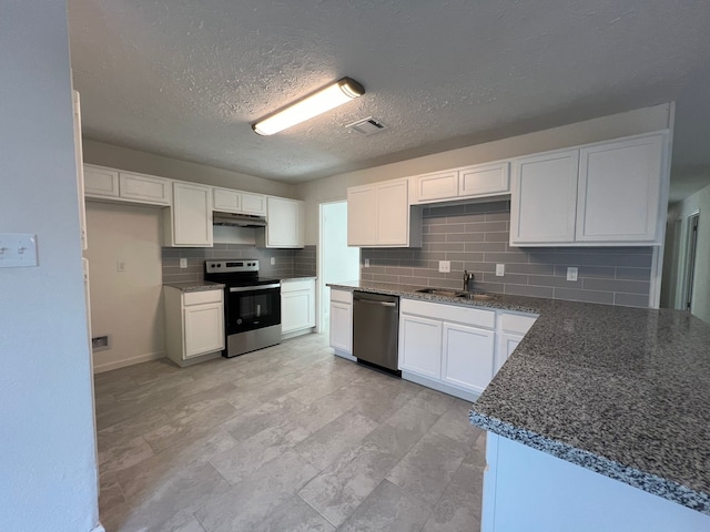 kitchen with appliances with stainless steel finishes, white cabinetry, sink, and tasteful backsplash