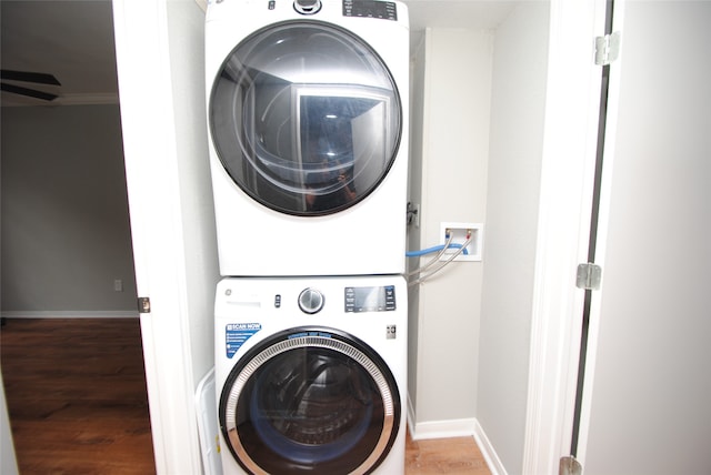 clothes washing area featuring stacked washer / drying machine, washer hookup, and hardwood / wood-style flooring