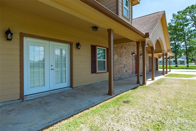 property entrance featuring french doors, a patio area, and a yard