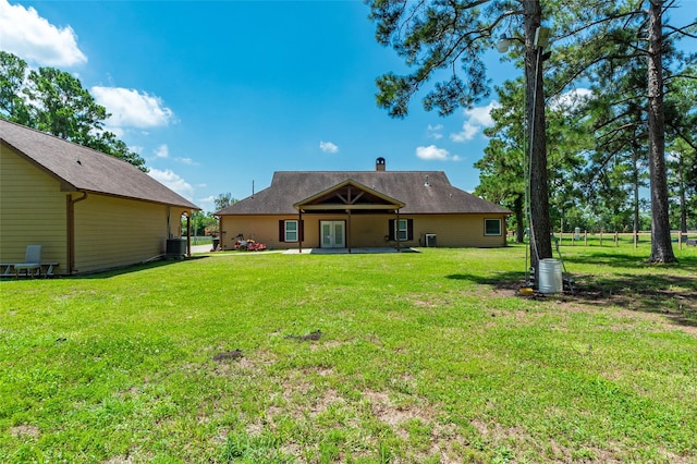 back of property featuring a yard and cooling unit