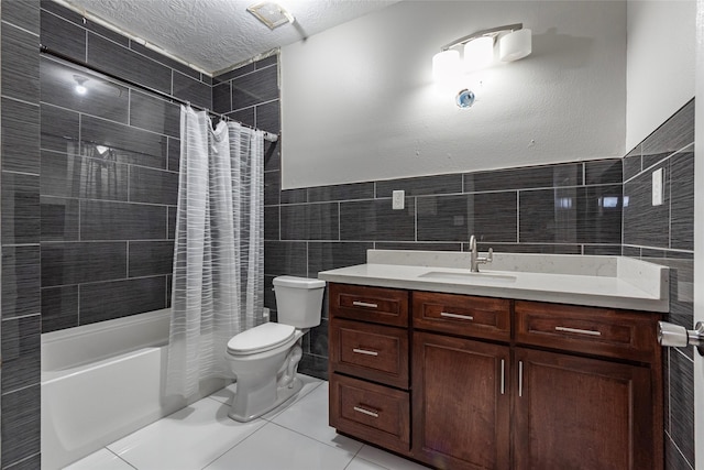 full bathroom featuring a textured ceiling, shower / bath combination with curtain, tile walls, tile patterned floors, and vanity