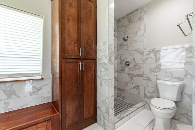 bathroom with tile walls, tiled shower, tile patterned floors, and toilet