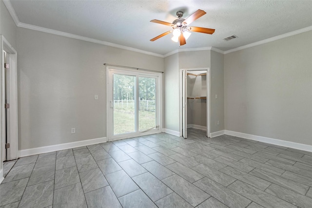 empty room with a textured ceiling, ceiling fan, and crown molding